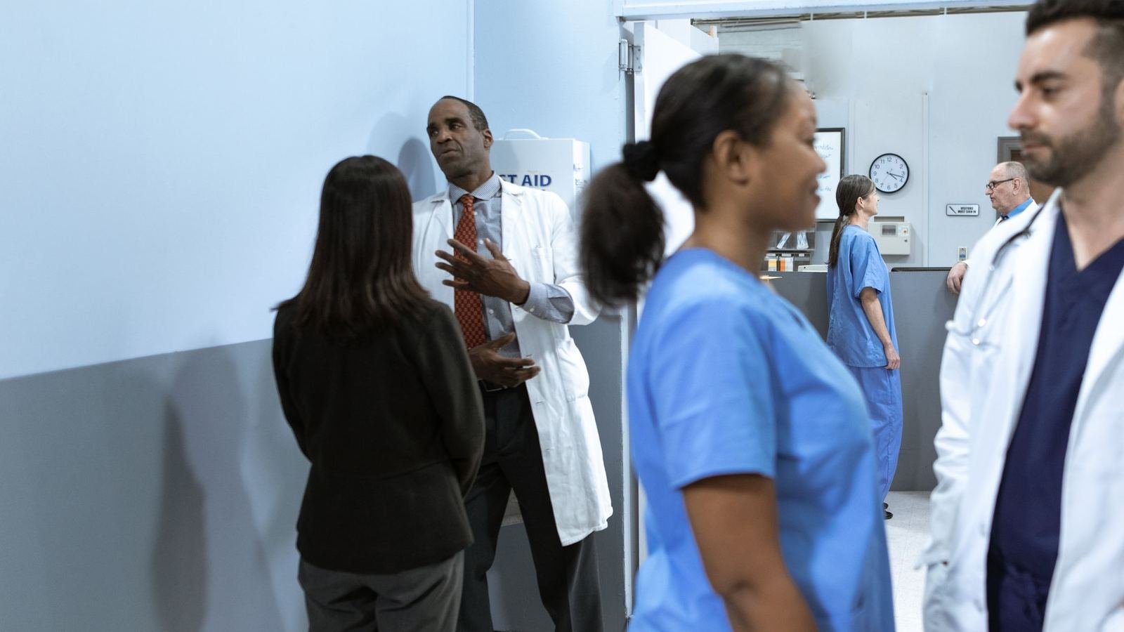 Equipe multiprofissional de saúde conversando no corredor de uma clínica